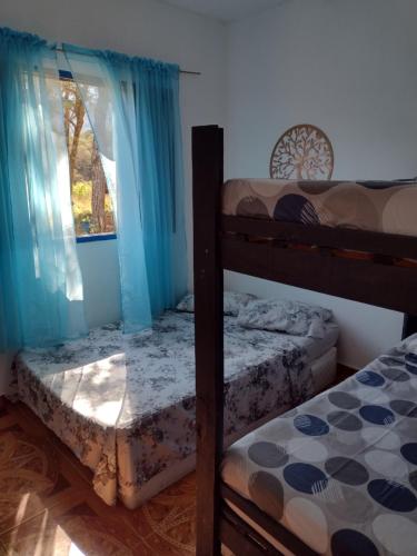two bunk beds in a room with a window at Achô na Roça STL in São Thomé das Letras