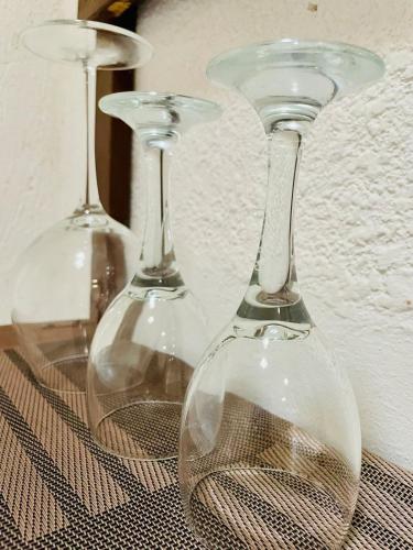 three glass wine glasses sitting on top of a table at La casita in Tizimín