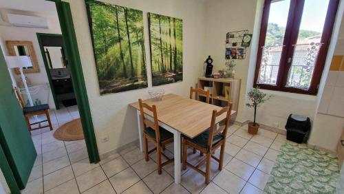 a dining room with a wooden table and chairs at Bo'Zen in Clermont-lʼHérault