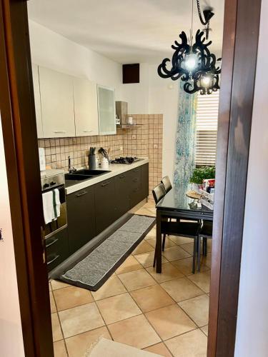 a kitchen with a table and a chandelier at Casa Yasmine in Santa Flavia