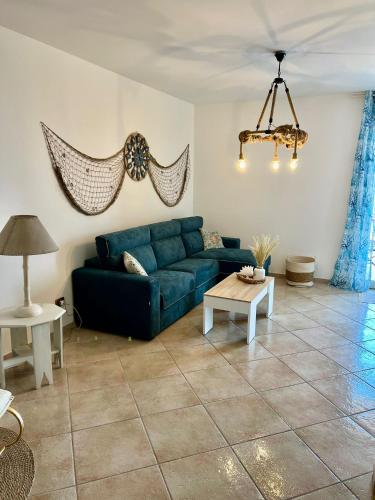 a living room with a blue couch and a table at Casa Yasmine in Santa Flavia