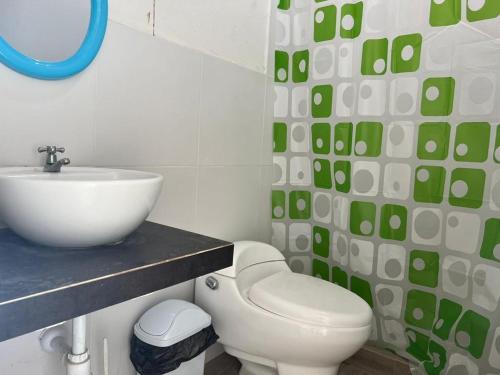 une salle de bain avec des toilettes blanches et un lavabo dans l'établissement Casa de Playa - Punta Sal, à La Bocana