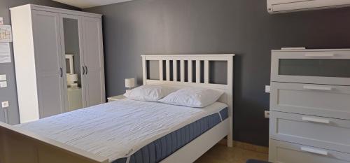 une chambre avec un lit blanc et une commode dans l'établissement GRAND Studio meublé-Juan Pins-Logt 5, à Antibes