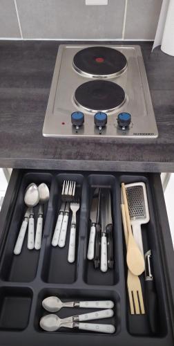 - un plateau d'ustensiles installé au-dessus d'une cuisinière dans l'établissement GRAND Studio meublé-Juan Pins-Logt 5, à Antibes