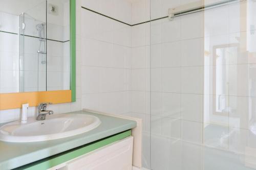 une salle de bain blanche avec un lavabo et une douche dans l'établissement Résidence Le Montana - maeva Home - 2 pièces 6 personnes Confort MAE-4632, à La Mongie