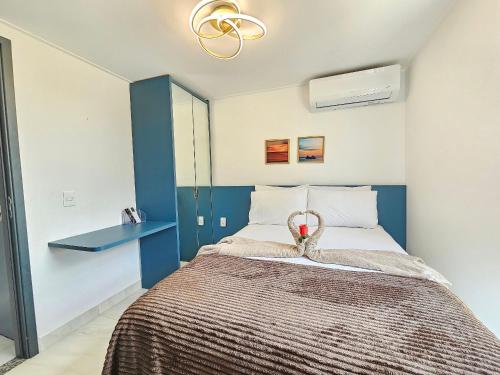 a bedroom with a bed with a blue accent wall at Flat pé na areia na praia de Porto de Galinhas próximo as piscinas naturais. in Porto De Galinhas