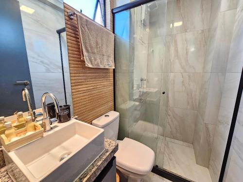 a bathroom with a sink and a toilet and a shower at Flat pé na areia na praia de Porto de Galinhas próximo as piscinas naturais. in Porto De Galinhas