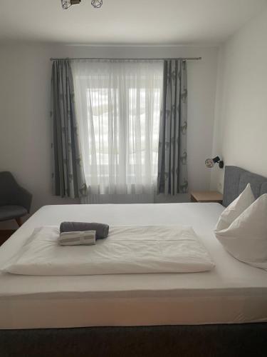 a large white bed with a window in a bedroom at Haus Alpenland in Wagrain