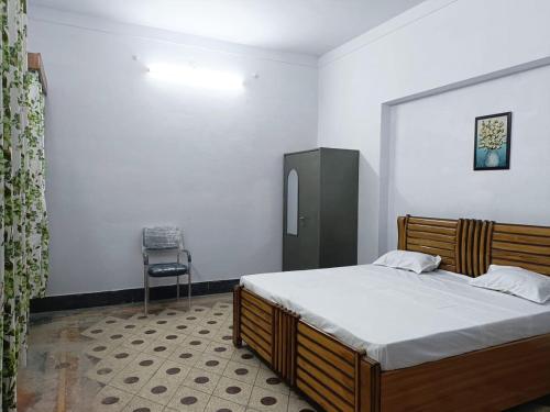 a bedroom with a bed and a chair at The Ganga Home Stay in Prayagraj
