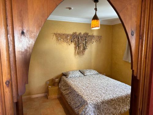 a bedroom with a bed and a chandelier at The Mogador's Oasis in Akermoud