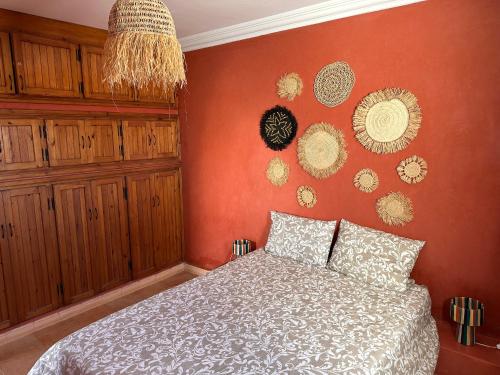 a bedroom with a bed and a orange wall at The Mogador's Oasis in Akermoud