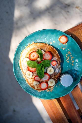 a blue plate with a pancake with fruit on it at Papagayo Golden Palms Beachfront Hotel in Papagayo, Guanacaste