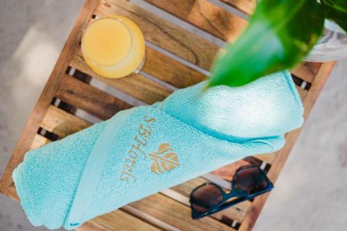 a table with a towel and a glass of juice at Papagayo Golden Palms Beachfront Hotel in Papagayo, Guanacaste