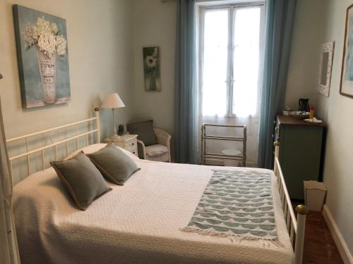 une chambre avec un grand lit et une fenêtre dans l'établissement Manoir St Hilaire, à Dampierre-sur-Boutonne