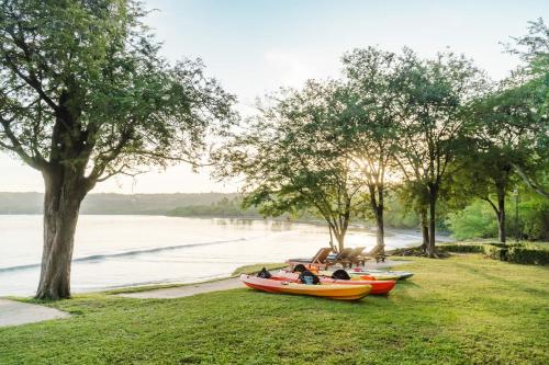 three kayaks parked on the grass next to the water at Papagayo Golden Palms Beachfront Hotel in Papagayo, Guanacaste