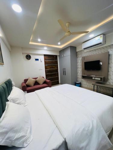 a bedroom with a large white bed and a couch at The Sleepy Monkey in Jaipur