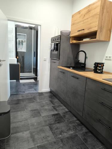 a kitchen with gray cabinets and a tile floor at Villa Baumhaus Apartments in Hamm