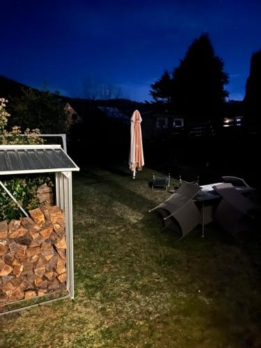 a backyard at night with an umbrella and a table at Ferienwohnung in Dahn in Dahn