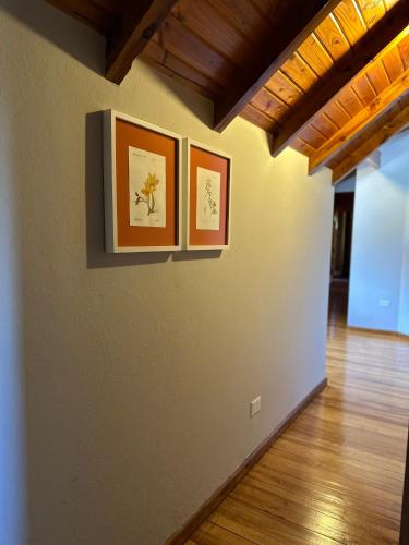 three pictures on the wall of a living room at El Pedregoso Casa Amarilla in Cholila