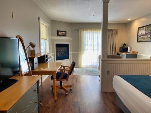 a hotel room with a desk and a bed and a room with a bed at Country Inn at Camden Rockport in Rockport