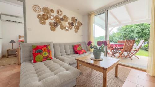 a living room with a couch and a table at Lagon privé du Diamant in Le Diamant