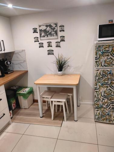 a table in a kitchen with a table and a plant at POD BZEM in Szczytna