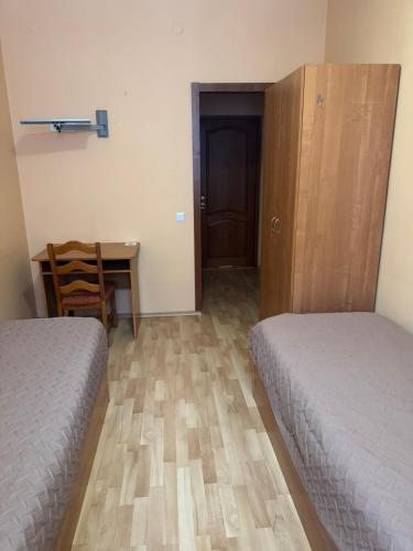 a bedroom with two beds and a desk and a table at Готель "Український Дворик" in Lviv