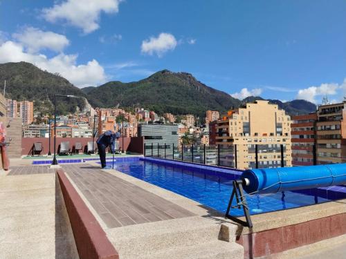 a man standing on the roof of a building with a pool at Suite con piscina in Bogotá