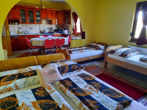 a living room with two beds and a kitchen at Méz-Bor Szállás in Báránd