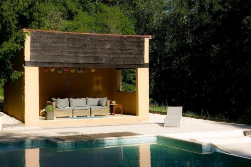 - un pavillon avec un canapé à côté de la piscine dans l'établissement Huge Dordogne House, heated pool, 5 acres, à Saint-André-dʼAllas