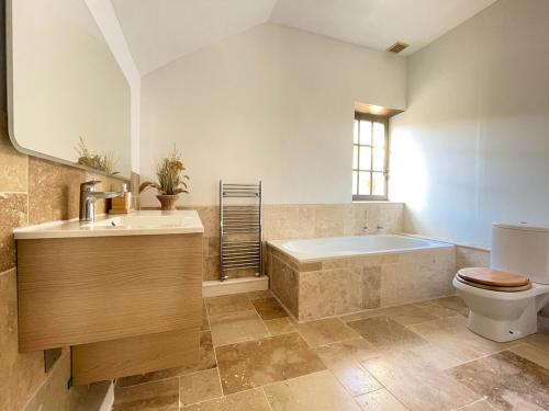 une salle de bain avec une baignoire, des toilettes et un lavabo dans l'établissement Huge Dordogne House, heated pool, 5 acres, à Saint-André-dʼAllas