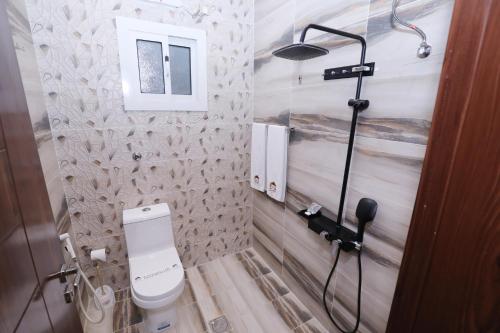 a bathroom with a toilet and a shower at شقق حديقة الروابي إين in Jeddah