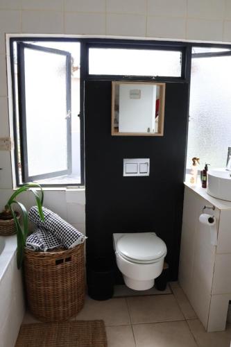a black bathroom with a toilet and a sink at sonsandsee in Hermanus