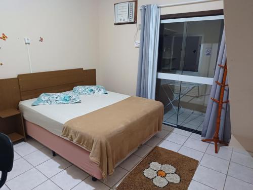 a small bedroom with a bed and a window at Lagoa Center House in Florianópolis