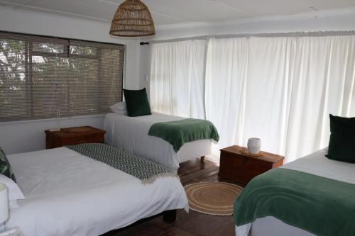 a bedroom with two beds and a window at sonsandsee in Hermanus