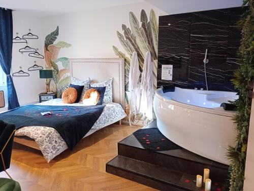 a bedroom with a bed and a bath tub at Spa-Sauna-Ciel de pluie tropicale-Champagne Nuit Romantique - Escapade Mâconnaise in Mâcon