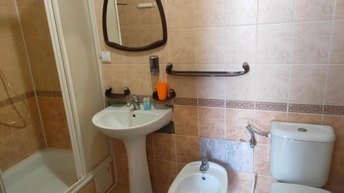 a bathroom with a sink and a toilet and a mirror at Готель "Український Дворик" in Lviv