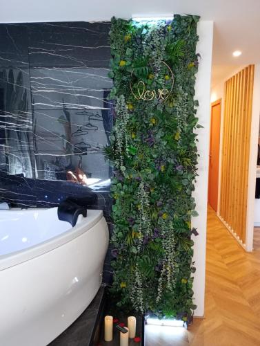 a bathroom with a plant wall next to a bath tub at Spa-Sauna-Ciel de pluie tropicale-Champagne Nuit Romantique - Escapade Mâconnaise in Mâcon