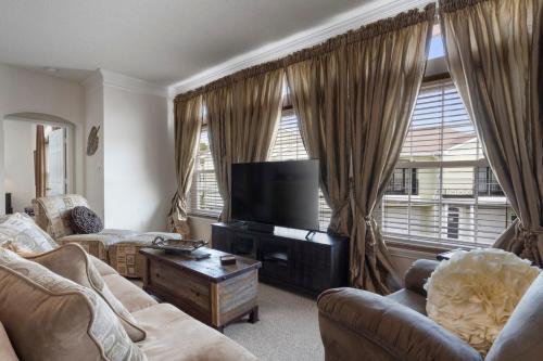 a living room with couches and a flat screen tv at Seaside Comfort in Gulfport