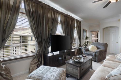 a living room with a television and a couch and a chair at Seaside Comfort in Gulfport