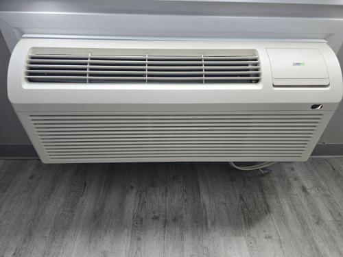 an air conditioner in a room with a wooden floor at Best Western Hotel Brossard in Brossard
