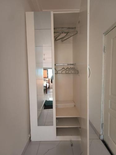 a white closet with a mirror in a room at Empress White House Accra in Tema