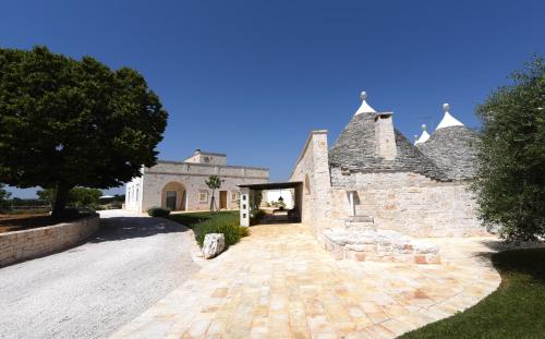 a large stone building with a brick driveway at Trulli di Mezza in Cisternino