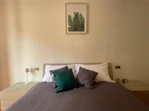 a bedroom with a bed with green and white pillows at Mountain Getaway Panoramic View in Gromo
