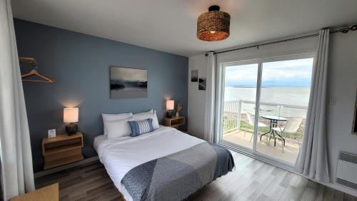una camera da letto con un letto e vista sull'oceano di La Plage Motel a Berthier-sur-Mer