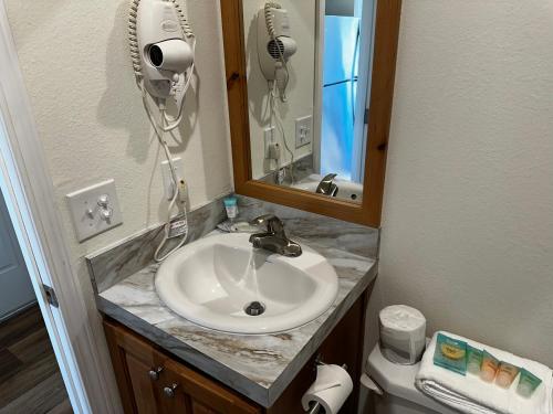 a bathroom with a sink and a hair dryer at Westport Inn Cabins in Westport
