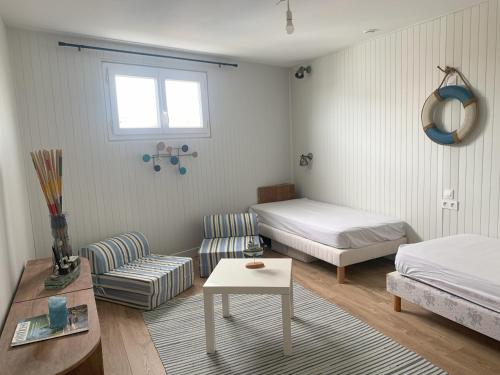 une chambre avec un lit, un canapé et une table dans l'établissement Les Louisettes, à Grand-Village-Plage