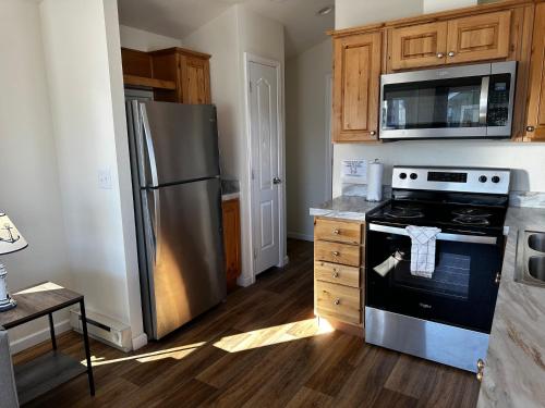 a kitchen with a stove and a refrigerator at Westport Inn Cabins in Westport