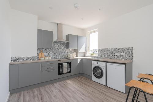 a kitchen with a washer and dryer at Spacious 3 bed flat- Free parking Edinburgh & Fife in Inverkeithing
