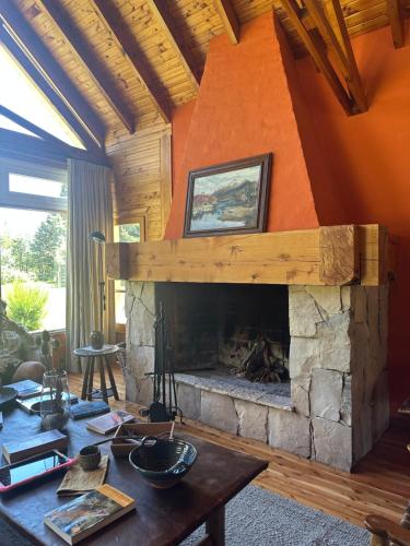a living room with a fireplace and a table at El Pedregoso Casa Amarilla in Cholila